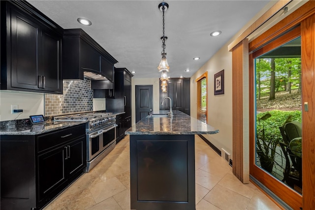101 Jane Kirk Ct, Center Twp, PA 15001 - kitchen with dark cabinetry, range with two ovens, tasteful backsplash, an island with sink, and recessed lighting