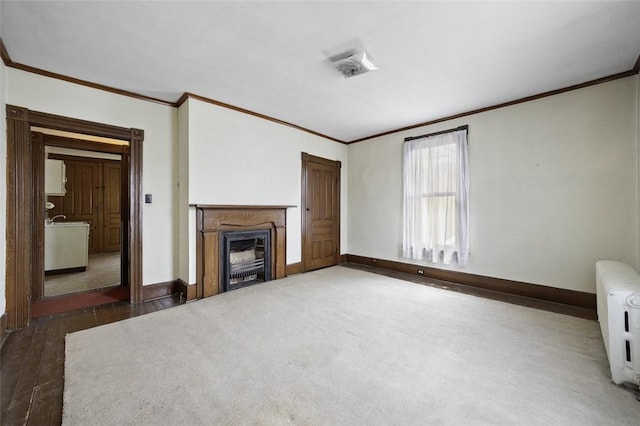 425 Concord Ave, City Of Greensburg, PA 15601 - unfurnished living room featuring crown molding, radiator heating unit, a fireplace, carpet, and wood finished floors