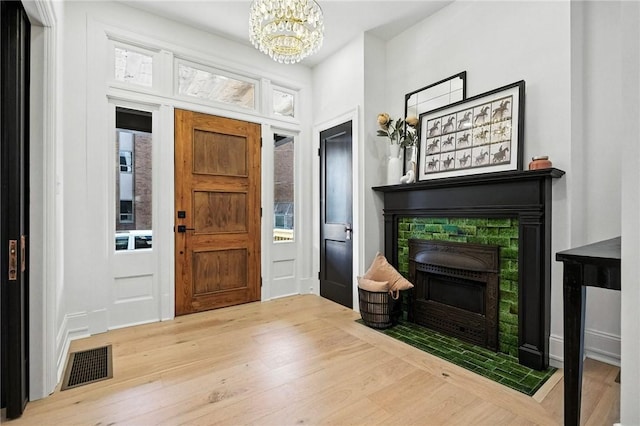 605 N Beatty, East Liberty, PA 15206 - foyer entrance with a fireplace with flush hearth, a chandelier, and wood finished floors