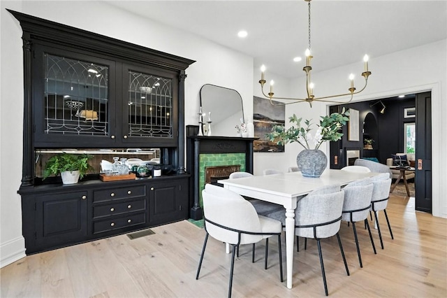 605 N Beatty, East Liberty, PA 15206 - dining area with light wood-type flooring, a fireplace, a chandelier, arched walkways, and recessed lighting