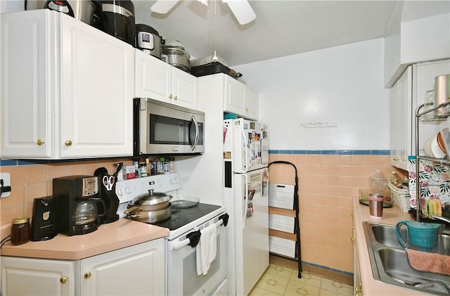 300 Sherman Ave, Dravosburg, PA 15034 - kitchen with white appliances, white cabinetry, tile walls, a ceiling fan, and light countertops