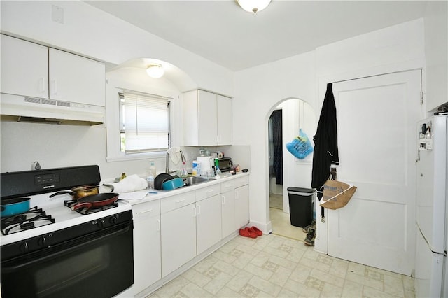 300 Sherman Ave, Dravosburg, PA 15034 - kitchen featuring range with gas cooktop, under cabinet range hood, arched walkways, refrigerator, and light countertops