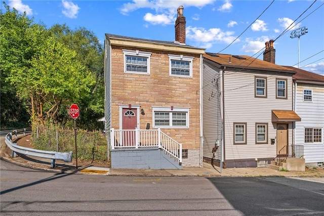 98 S 9th St, South Side, PA 15203 - view of property featuring a chimney, stone siding, and entry steps