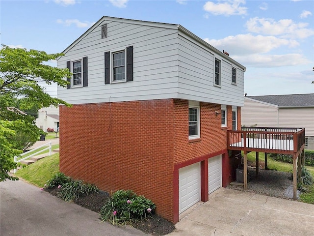 240 Wallingford Dr, Ross Twp, PA 15237 - view of side of home with brick siding, a deck, a garage, and concrete driveway