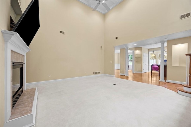 402 Providence Ct, Adams Twp, PA 16059 - unfurnished living room with ornate columns, a ceiling fan, a tile fireplace, light carpet, and a high ceiling