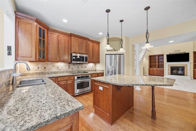 402 Providence Ct, Adams Twp, PA 16059 - kitchen with appliances with stainless steel finishes, light stone countertops, a kitchen breakfast bar, glass insert cabinets, and light wood-type flooring