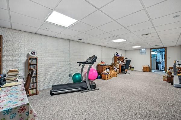 3129 Saranac Dr, South Pymatuning Twp, PA 16150 - exercise area with a drop ceiling, carpet flooring, and brick wall