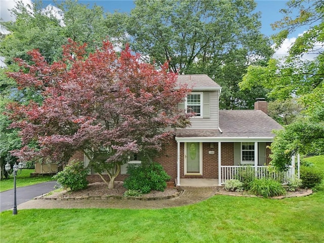 108 Colonial Dr, Leet Twp, PA 15143 - view of front facade with covered porch, a front lawn, a chimney, brick siding, and roof with shingles