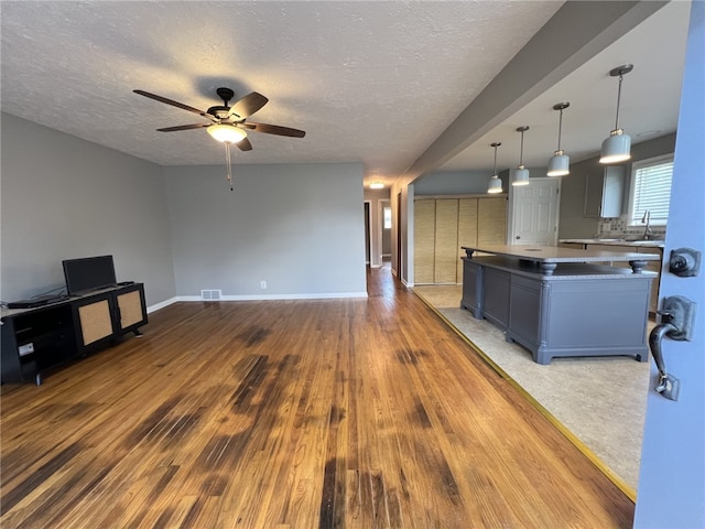 43 Barton Mill Rd, South Union Twp, PA 15401 - kitchen featuring a kitchen island, ceiling fan, wood finished floors, open floor plan, and a textured ceiling