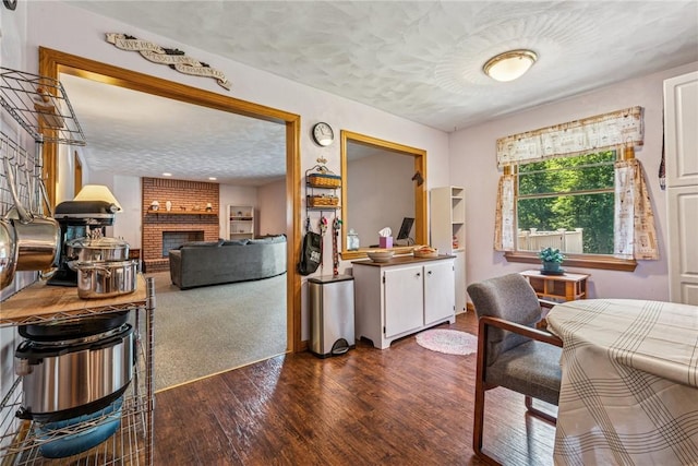 915 Jamell Dr, Unity Twp, PA 15601 - dining area with a textured ceiling, dark wood-style flooring, and a brick fireplace