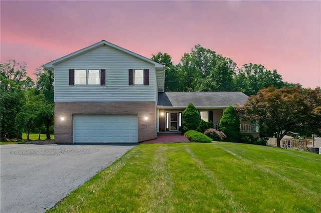 915 Jamell Dr, Unity Twp, PA 15601 - view of front facade with brick siding, driveway, an attached garage, and a front lawn