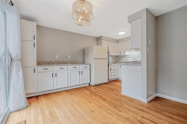 226 Glen Spring Cir, North Strabane, PA 15317 - kitchen with freestanding refrigerator, stove, light wood-type flooring, white cabinetry, and light stone counters