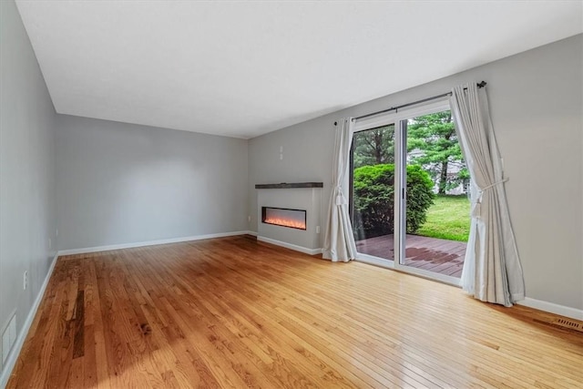 226 Glen Spring Cir, North Strabane, PA 15317 - unfurnished living room with hardwood / wood-style floors and a glass covered fireplace