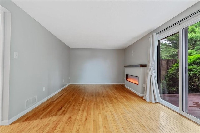 226 Glen Spring Cir, North Strabane, PA 15317 - unfurnished living room featuring light wood-type flooring and a glass covered fireplace