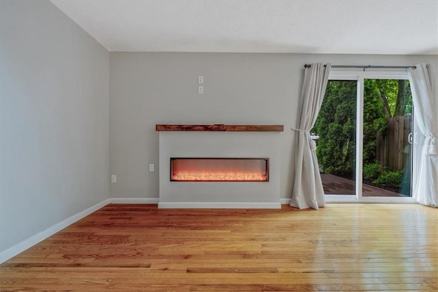 226 Glen Spring Cir, North Strabane, PA 15317 - unfurnished living room featuring wood-type flooring and a glass covered fireplace