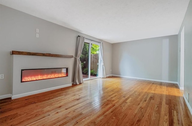 226 Glen Spring Cir, North Strabane, PA 15317 - unfurnished living room featuring a glass covered fireplace and wood finished floors