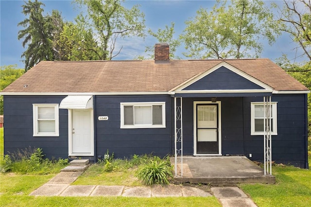 1048 Unity Center Rd, Plum Boro, PA 15239 - bungalow with roof with shingles, a chimney, and a front yard