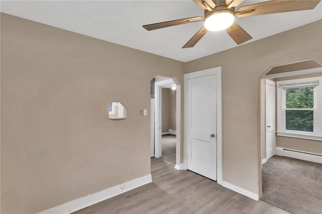 1048 Unity Center Rd, Plum Boro, PA 15239 - spare room with arched walkways, ceiling fan, baseboard heating, and light wood finished floors
