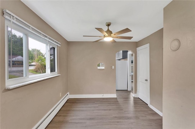 1048 Unity Center Rd, Plum Boro, PA 15239 - spare room featuring a ceiling fan, baseboard heating, wood finished floors, and arched walkways