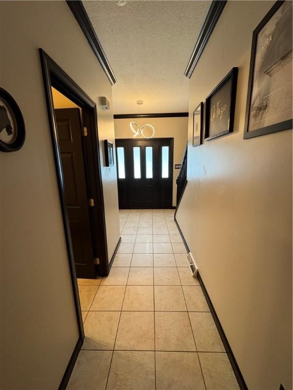 91 Celtic Ash Ct, Cranberry Twp, PA 16066 - hallway with crown molding, light tile patterned floors, a textured ceiling, and a chandelier
