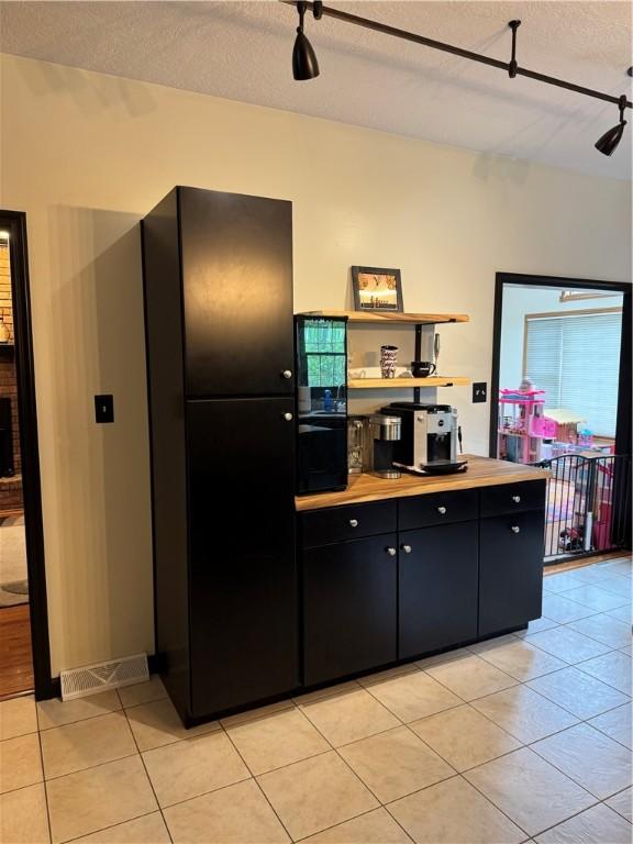 91 Celtic Ash Ct, Cranberry Twp, PA 16066 - kitchen with light tile patterned flooring, a textured ceiling, dark cabinetry, and light countertops
