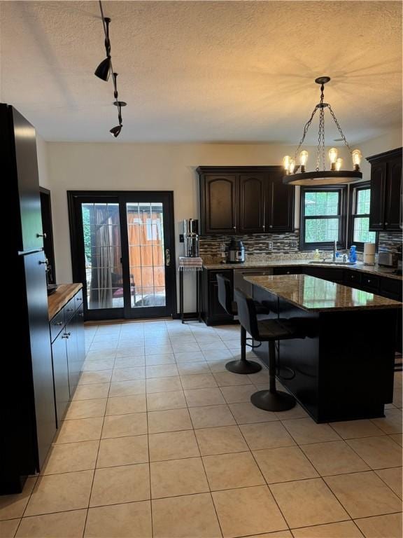 91 Celtic Ash Ct, Cranberry Twp, PA 16066 - kitchen with freestanding refrigerator, track lighting, backsplash, a chandelier, and hanging light fixtures