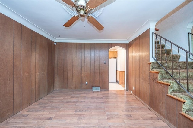 246 Maple Dr, Monroeville, PA 15146 - spare room featuring arched walkways, ceiling fan, wood finished floors, stairway, and wooden walls