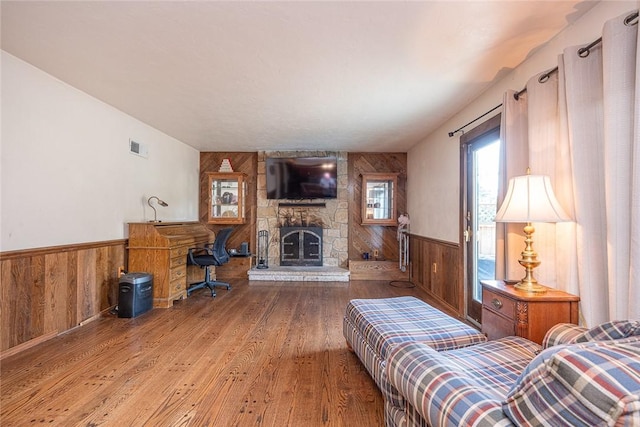 315 Pennsylvania Ave, Plum Boro, PA 15147 - living area with wood walls, wood finished floors, wainscoting, and a stone fireplace