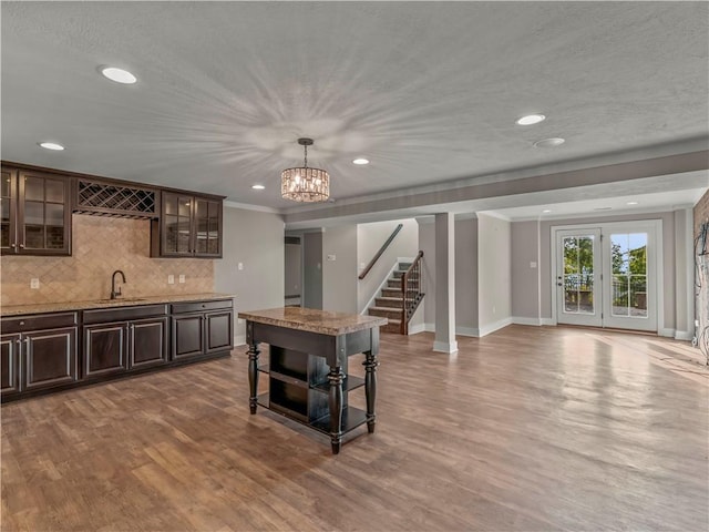 4402 Walnut Ridge Cir, South Fayette, PA 15057 - kitchen featuring dark brown cabinetry, decorative backsplash, ornamental molding, wood finished floors, and glass insert cabinets