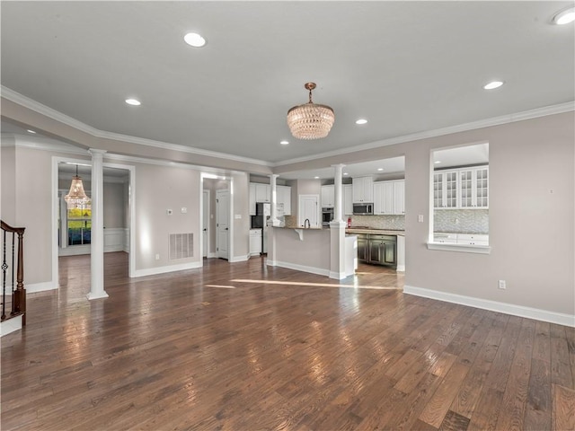 4402 Walnut Ridge Cir, South Fayette, PA 15057 - unfurnished living room with dark wood-style floors, a chandelier, recessed lighting, ornamental molding, and ornate columns