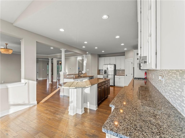4402 Walnut Ridge Cir, South Fayette, PA 15057 - kitchen featuring appliances with stainless steel finishes, decorative columns, hardwood / wood-style flooring, decorative backsplash, and white cabinetry
