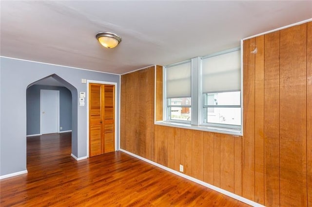 650 Loretta St, Greenfield, PA 15217 - empty room featuring arched walkways, wood finished floors, and wood walls