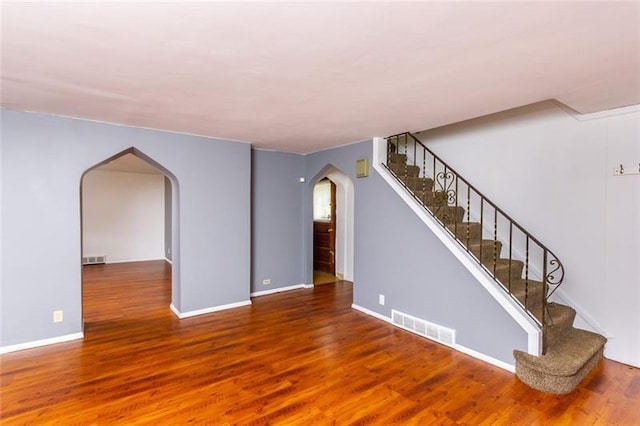 650 Loretta St, Greenfield, PA 15217 - unfurnished living room with arched walkways, wood finished floors, and stairs