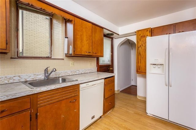 650 Loretta St, Greenfield, PA 15217 - kitchen with white appliances, arched walkways, light wood-type flooring, light countertops, and brown cabinets