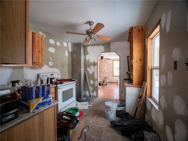 1276 Glades Pike, Somerset, PA 15501 - kitchen with white electric stove, a ceiling fan, brown cabinets, and arched walkways