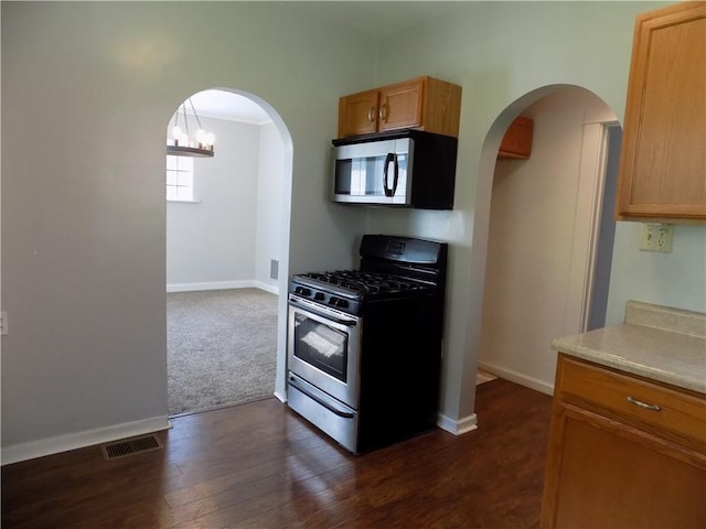 437 Green St, Munhall, PA 15120 - kitchen with appliances with stainless steel finishes, arched walkways, light countertops, dark wood-type flooring, and dark colored carpet