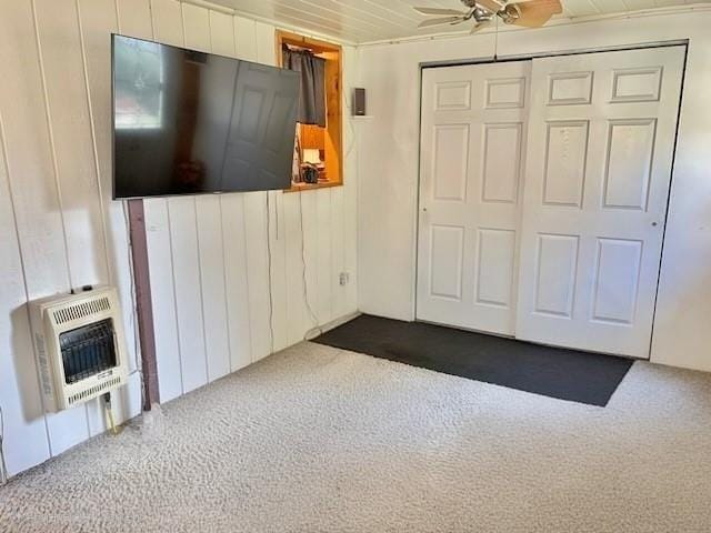 1117 Idaho Ave, Harrison Twp, PA 15065 - unfurnished living room featuring heating unit, dark carpet, a ceiling fan, and wooden walls