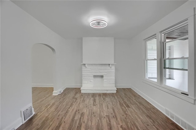 1311 Irwin St, Aliquippa, PA 15001 - unfurnished living room with wood finished floors, arched walkways, and a fireplace