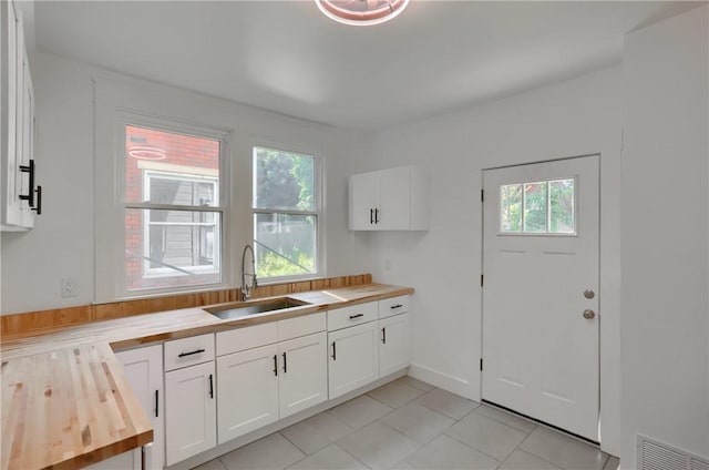 1311 Irwin St, Aliquippa, PA 15001 - kitchen featuring butcher block counters, light tile patterned flooring, and white cabinets