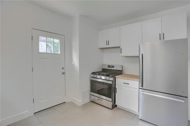 1311 Irwin St, Aliquippa, PA 15001 - kitchen with stainless steel appliances, white cabinets, light countertops, and light tile patterned floors