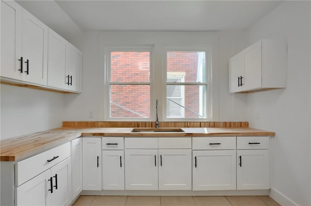 1311 Irwin St, Aliquippa, PA 15001 - kitchen with wooden counters, white cabinets, and light tile patterned floors