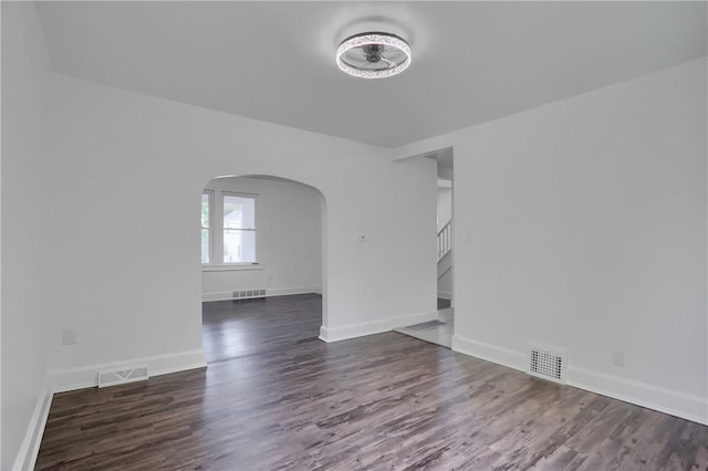 1311 Irwin St, Aliquippa, PA 15001 - empty room with arched walkways, dark wood-style floors, stairway, and a ceiling fan