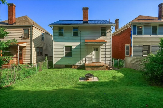 1311 Irwin St, Aliquippa, PA 15001 - rear view of house featuring a standing seam roof, a fenced backyard, a metal roof, and a chimney