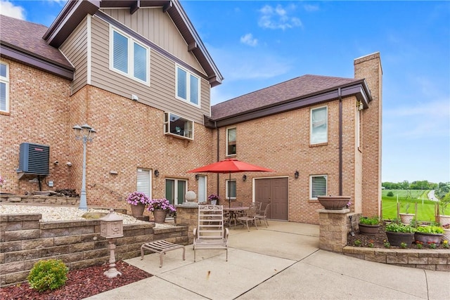 204 S Links Ave, Twp Of But Nw, PA 16001 - rear view of property featuring a patio area, a chimney, brick siding, outdoor dining space, and roof with shingles