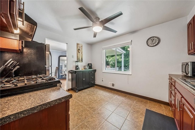 249 Laurie Dr, Penn Hills, PA 15235 - kitchen featuring freestanding refrigerator, stainless steel microwave, ceiling fan, dark countertops, and light tile patterned floors