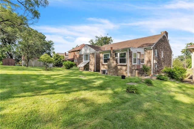 200 Champa St, Penn Hills, PA 15235 - rear view of house featuring a storage shed, a lawn, a chimney, and brick siding
