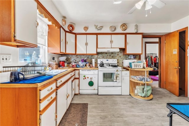 200 Champa St, Penn Hills, PA 15235 - kitchen with white appliances, under cabinet range hood, light countertops, white cabinetry, and decorative backsplash