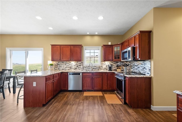 138 Crossridge Rd, Fallowfield, PA 15022 - kitchen featuring appliances with stainless steel finishes, a peninsula, dark wood-style floors, healthy amount of natural light, and recessed lighting