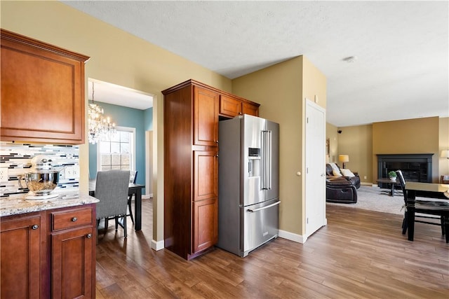 138 Crossridge Rd, Fallowfield, PA 15022 - kitchen with high end fridge, a chandelier, wood finished floors, open floor plan, and a glass covered fireplace