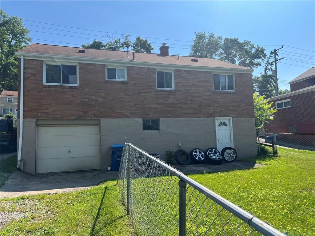 920 Jefferson Rd, Penn Hills, PA 15235 - rear view of property featuring brick siding, an attached garage, and driveway
